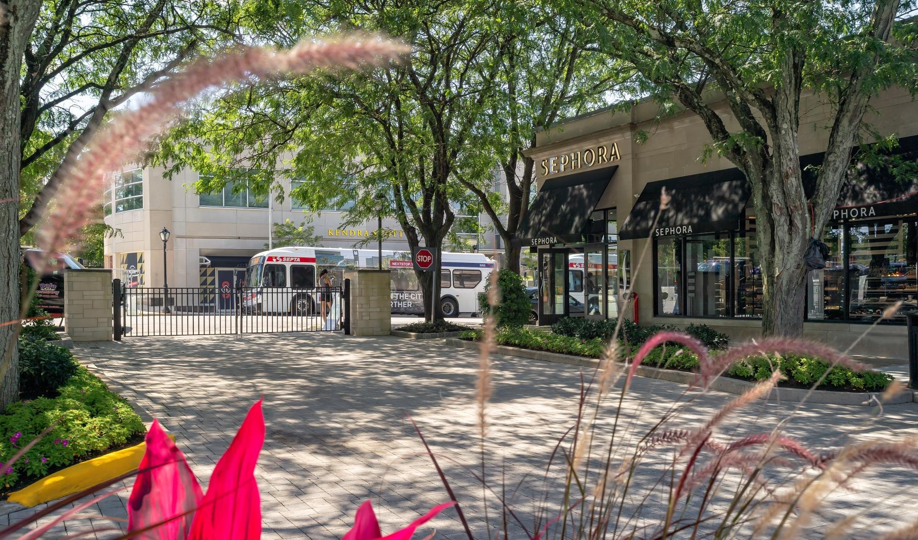 a brick walkway with a fence and trees and buildings