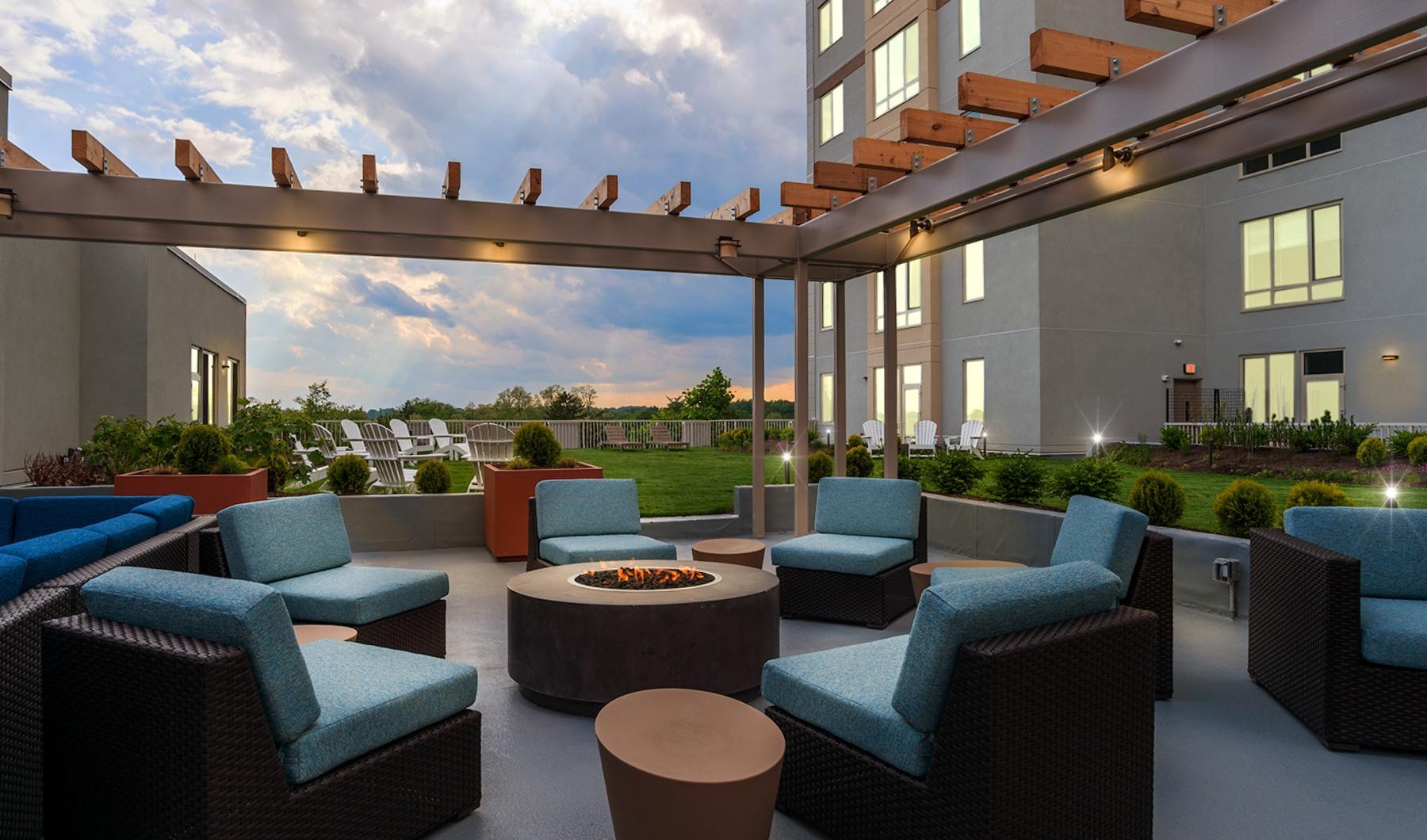a patio with blue chairs and a round table