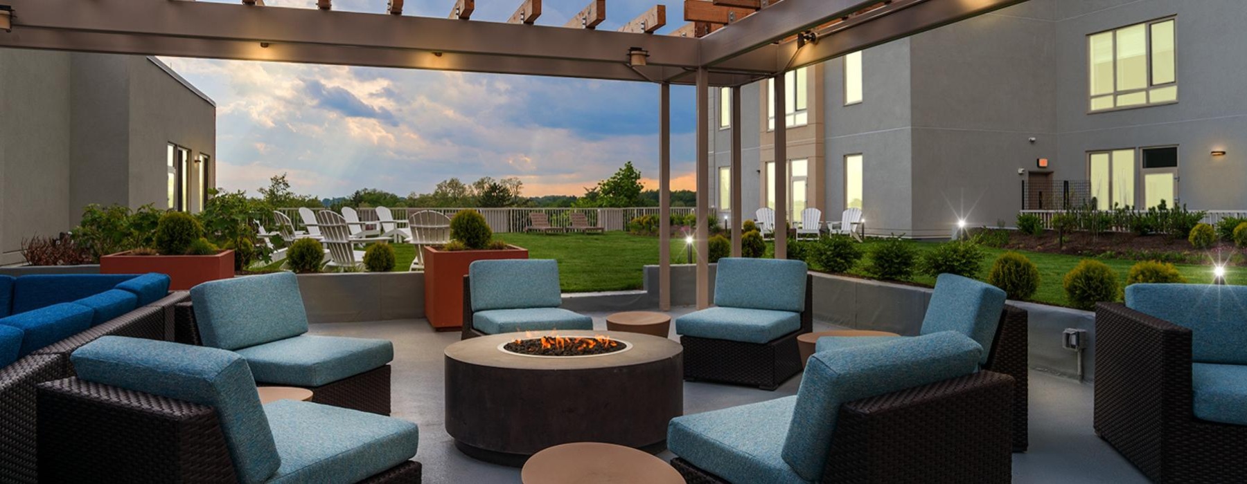 a patio with blue chairs and a round table